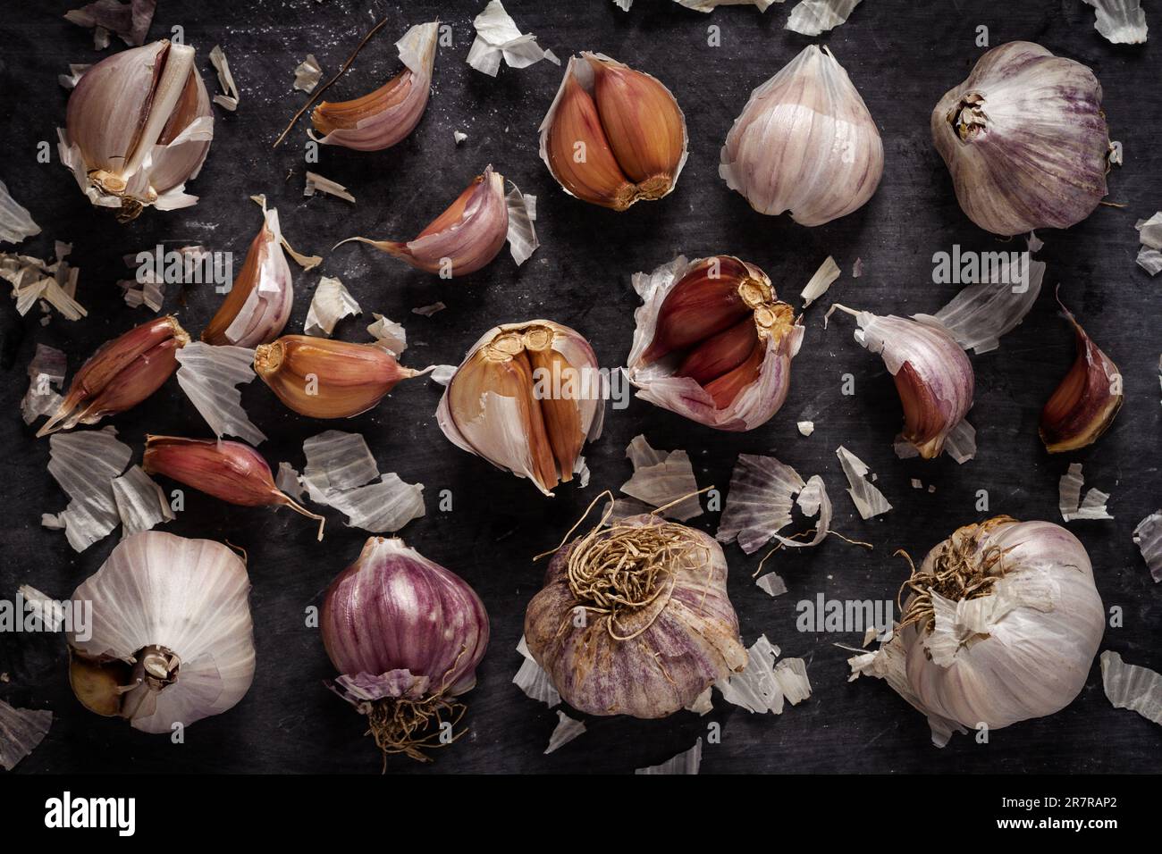 Fresh garlic bulbs and cloves grouped on black background. Flat lay ...