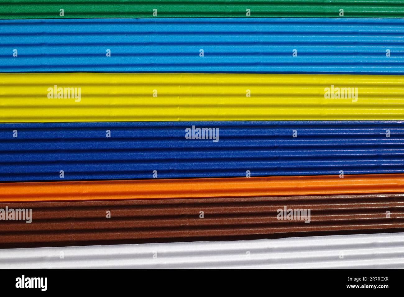 Horizontally ribbed cardboard with the colors white, brown, orange, indigo, yellow, blue, green. Meant as background Stock Photo
