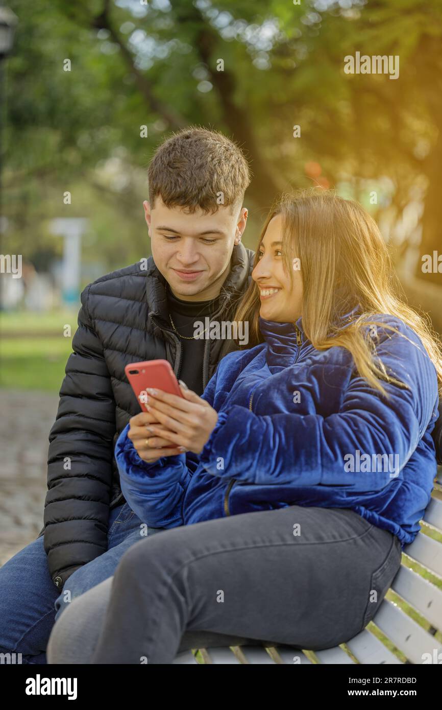 Couple in love sitting on a bench in a public park. Stock Photo