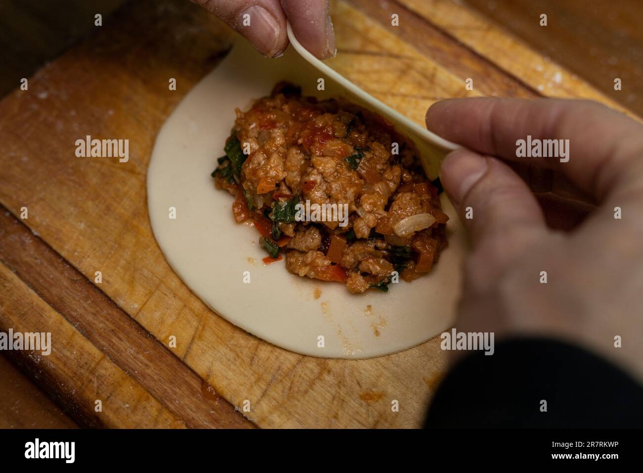 A person is preparing vegan and vegetarian Argentinian empanadas with a stuffing Stock Photo