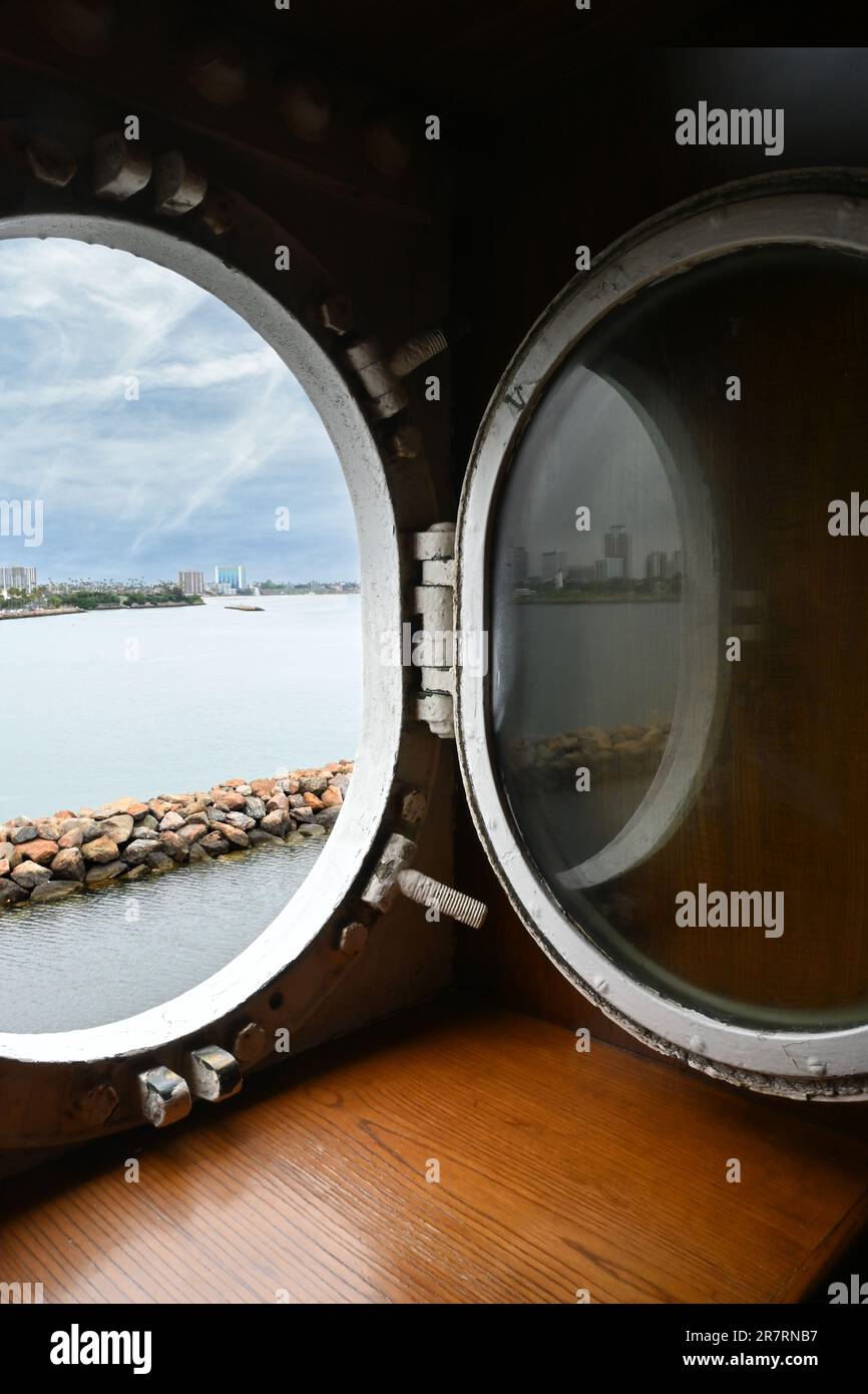 LONG BEACH, CALIFORNIA - 14 JUN 2023: View out the Port Hole on the Queen Mary with the bay and Long Beach Skyline in the distance. Stock Photo