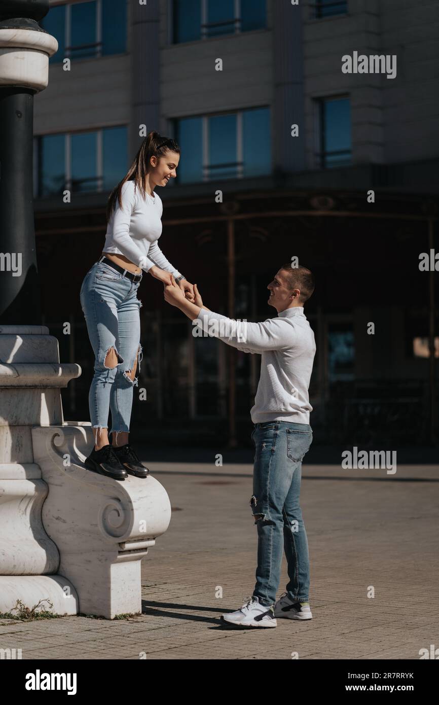 Beautiful girl trying to jump and her boyfriends is catching her at the ...