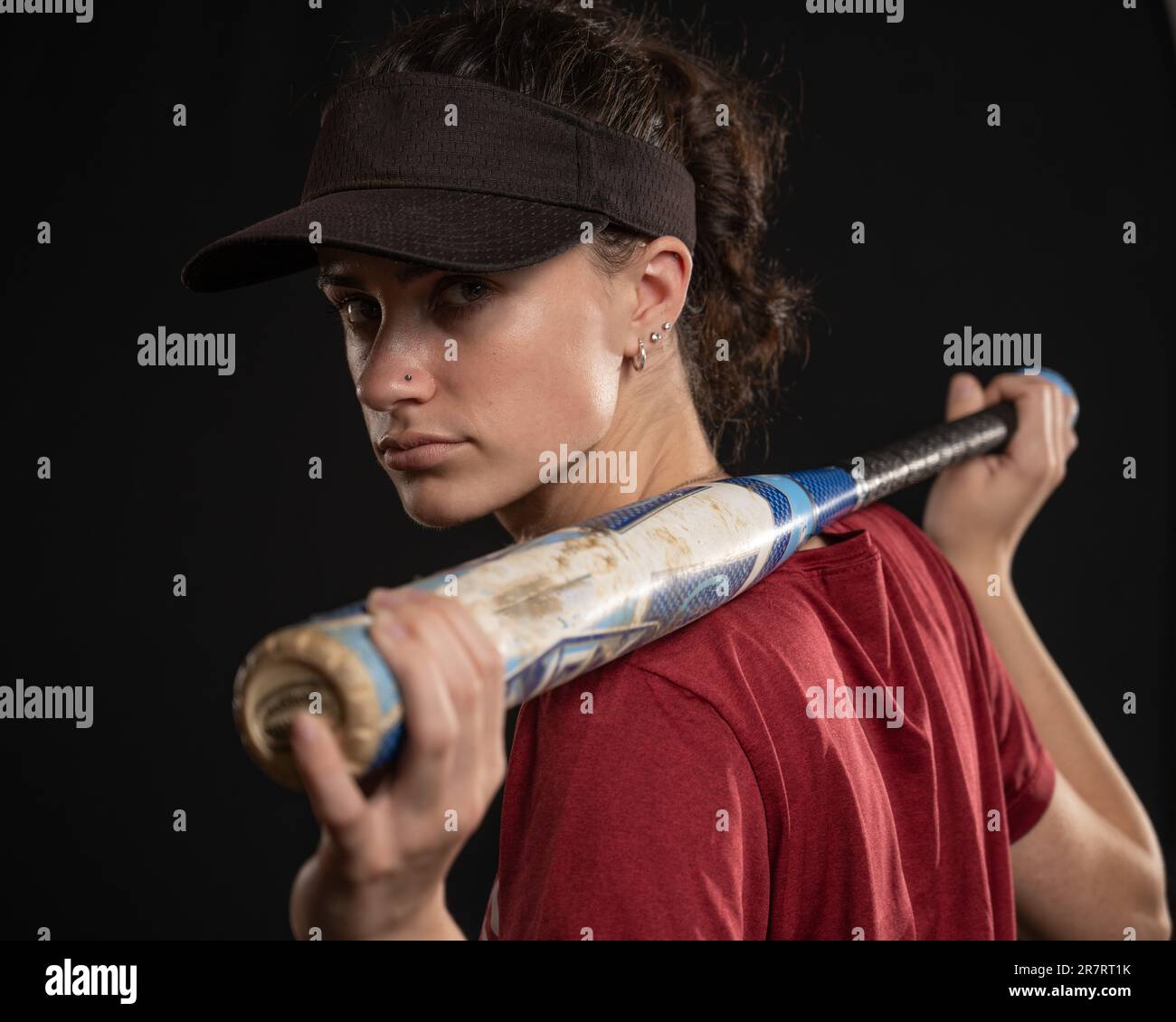 Athletic fast pitch softball player in red and black uniform has her