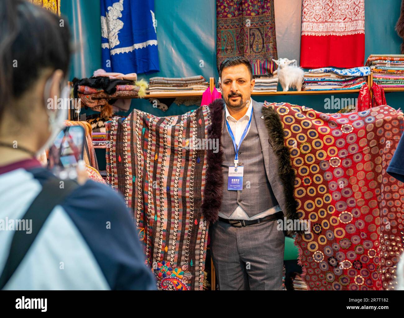 Lhasa, China's Tibet Autonomous Region. 17th June, 2023. An exhibitor from India displays shawls during the 5th China Xizang Tourism and Culture Expo in Lhasa, southwest China's Tibet Autonomous Region, June 17, 2023. The 5th China Xizang Tourism and Culture Expo opened here on Friday. The three-day expo is one of the most important events on Tibet's cultural calendar. Nearly 1,000 businesses from home and abroad have attended the event, bringing about 10,000 different products. Credit: Sun Fei/Xinhua/Alamy Live News Stock Photo