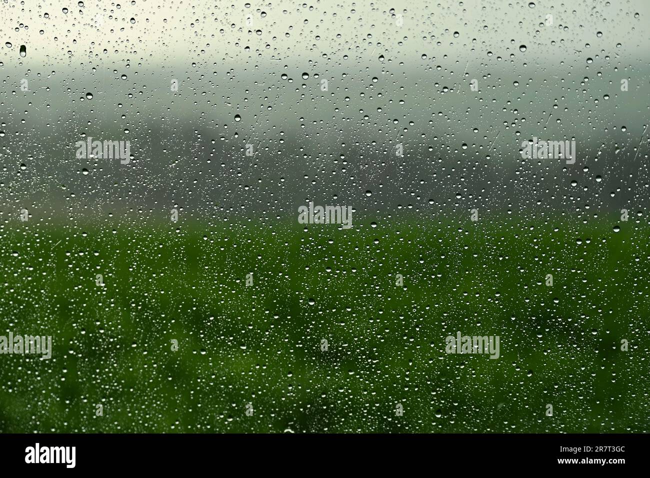 Drops on window with landscape and natural color background. Concept for rain and bad weather. Stock Photo