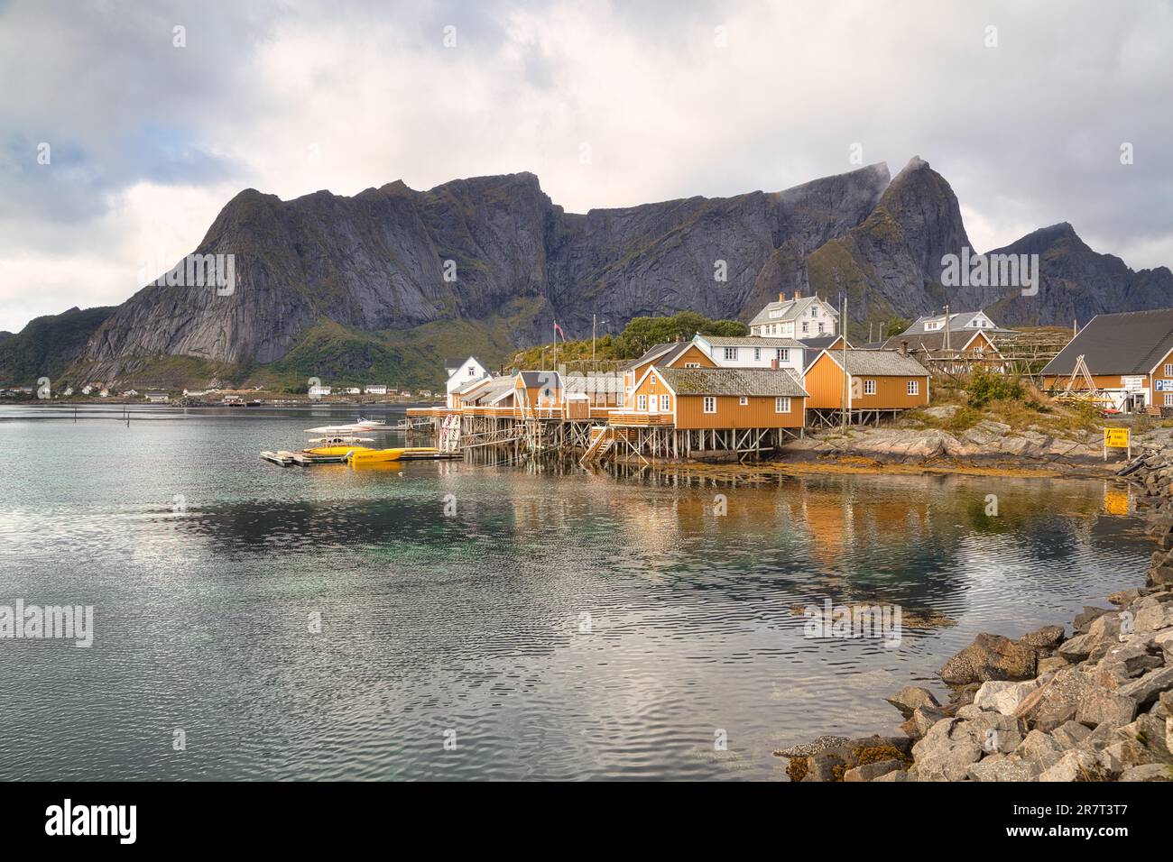 High Ruggedness Yellow rorbu houses on a stony shore, fishing boats, high, rugged ...