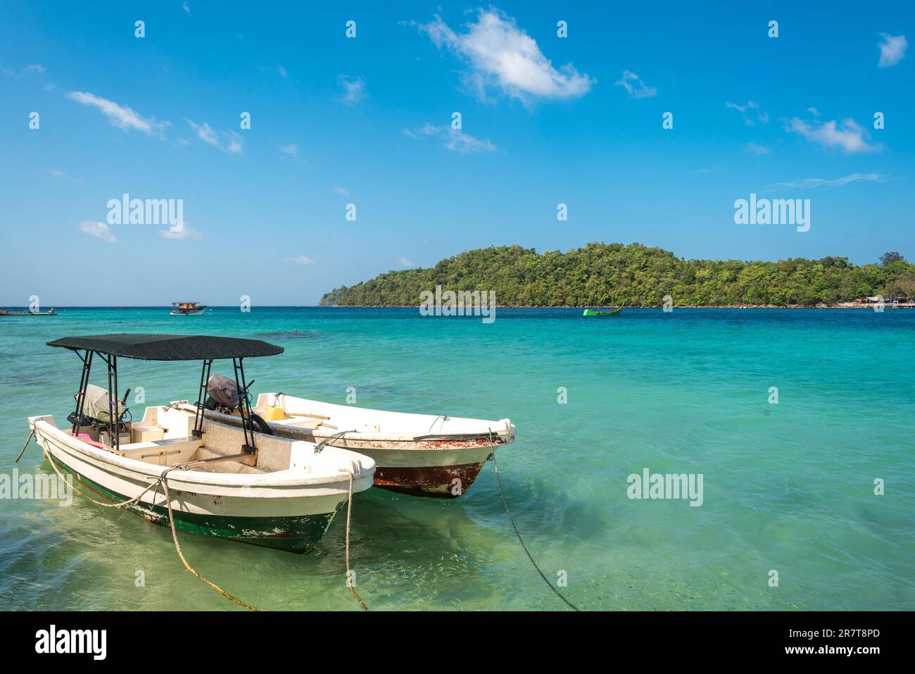 Two fishing boats are moored in the strait between the islet of Rubiah