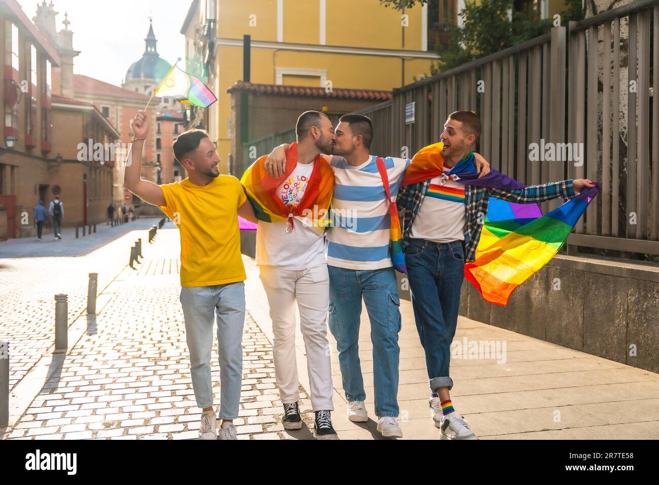 Couples of men having fun and kissing at the demonstration with the rainbow flags, gay pride party in the city, lgbt concept Stock Photo