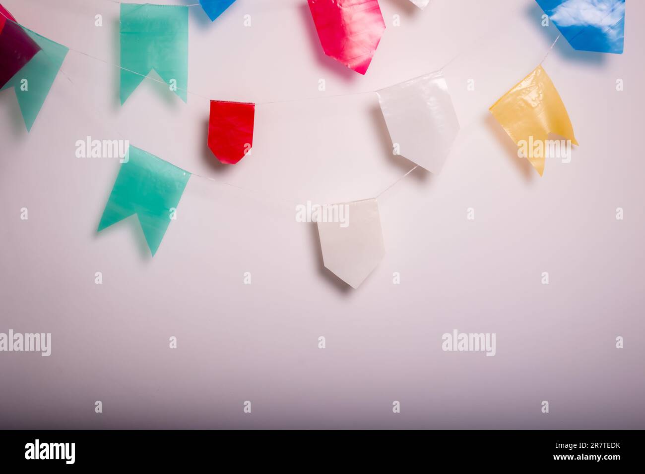 White wall festooned with colorful flags. Party Saint John June