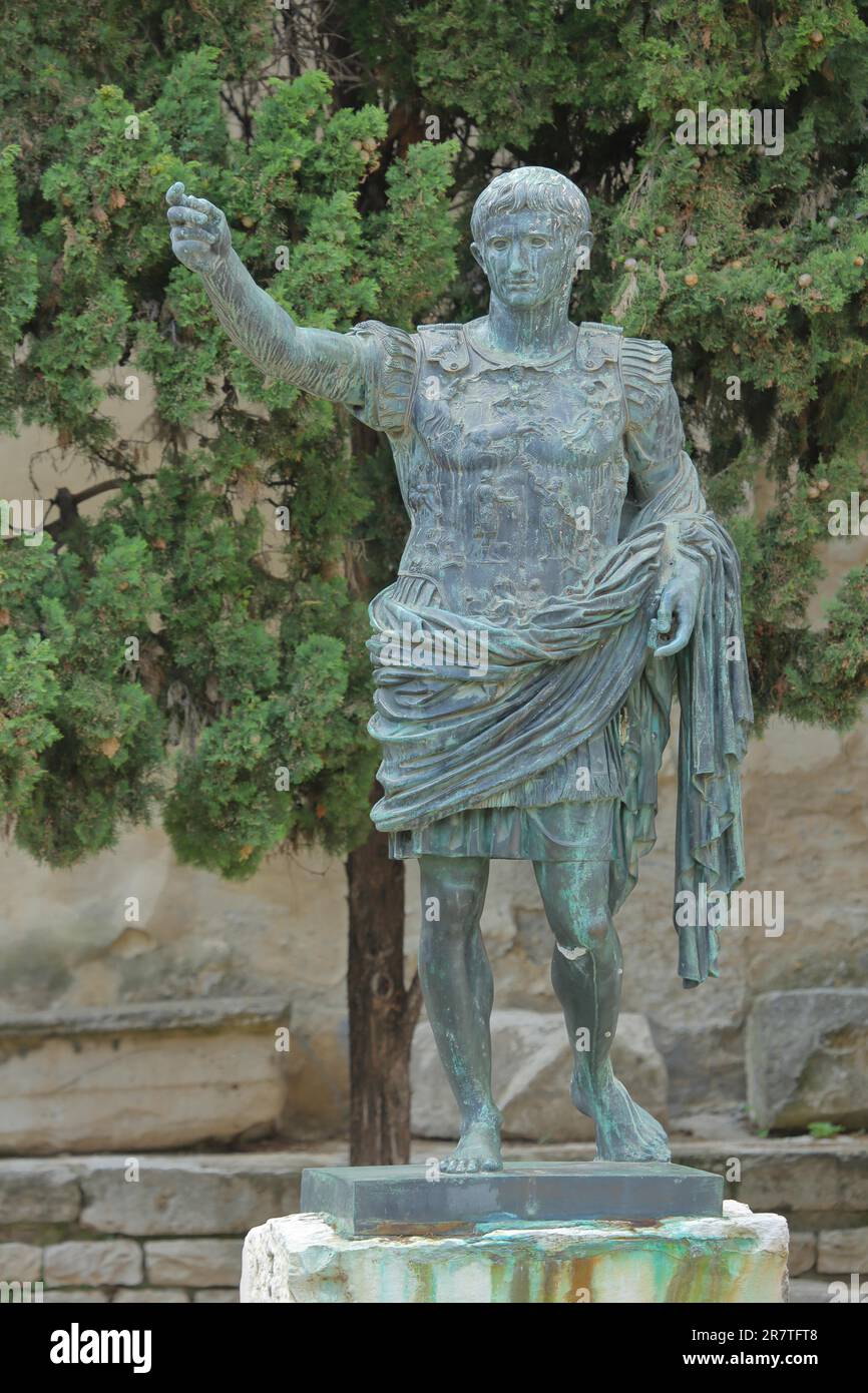 Statue of the 1st Roman Emperor Augustus at the archway Porte d'Auguste, gate, monument, first, ruler, sculpture, gesture, arm, high, victor, Nimes Stock Photo