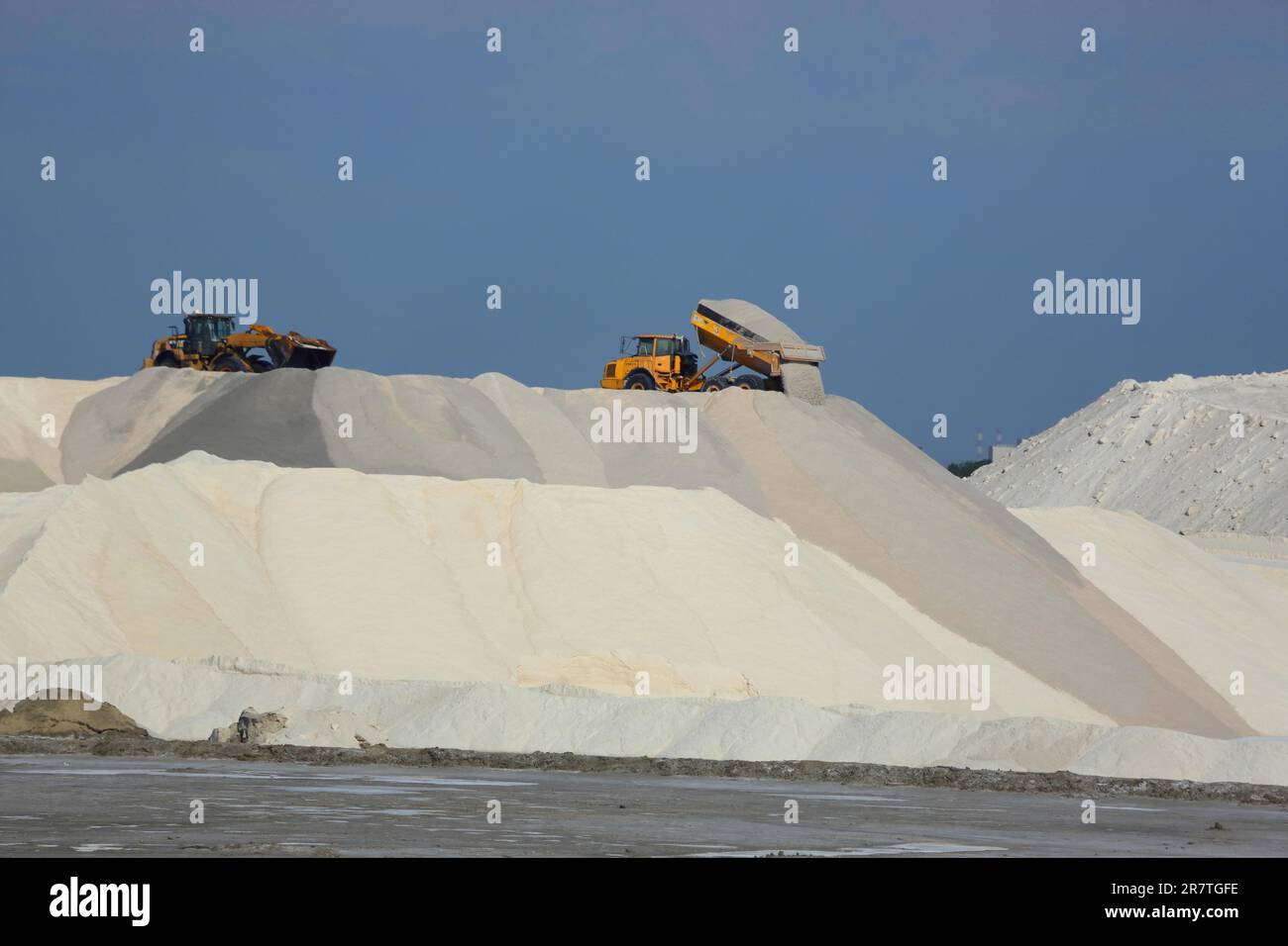 Dump truck unloading salt at a salt mine for salt extraction, salt