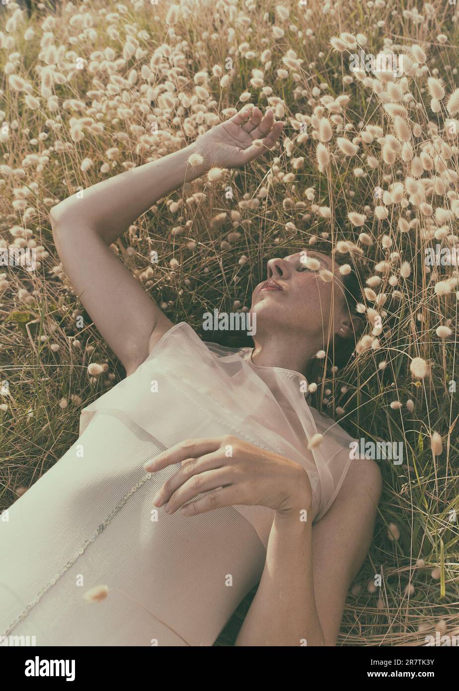 woman lying among harestail grass Stock Photo