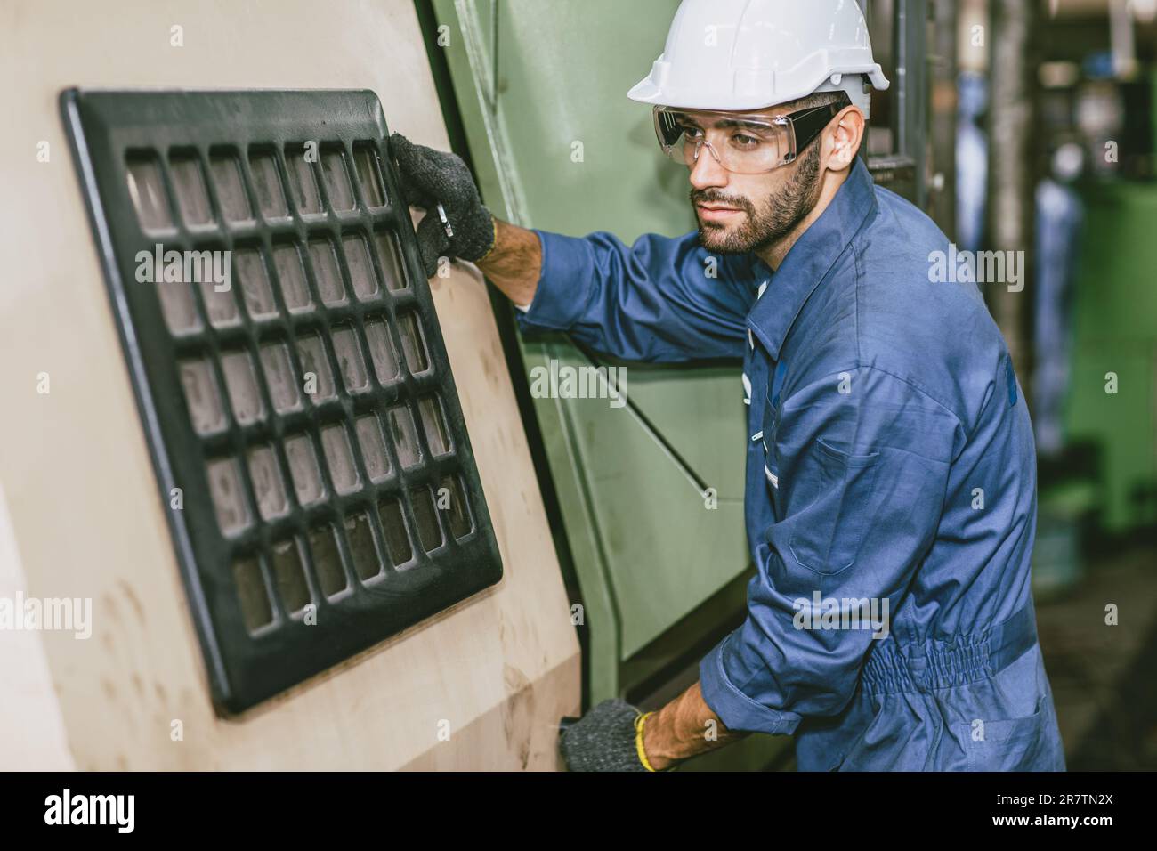 Male Worker Hispanic Latin Indian people Engineer working with CNC Lathe Machine in Heavy metal Factory. Stock Photo