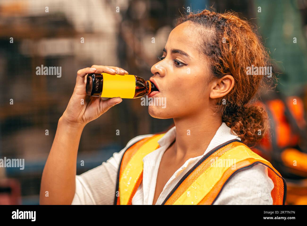 African American Woman Worker Drinking Energy Drink During Relax Brake Work In Heavy Factory. Stock Photo