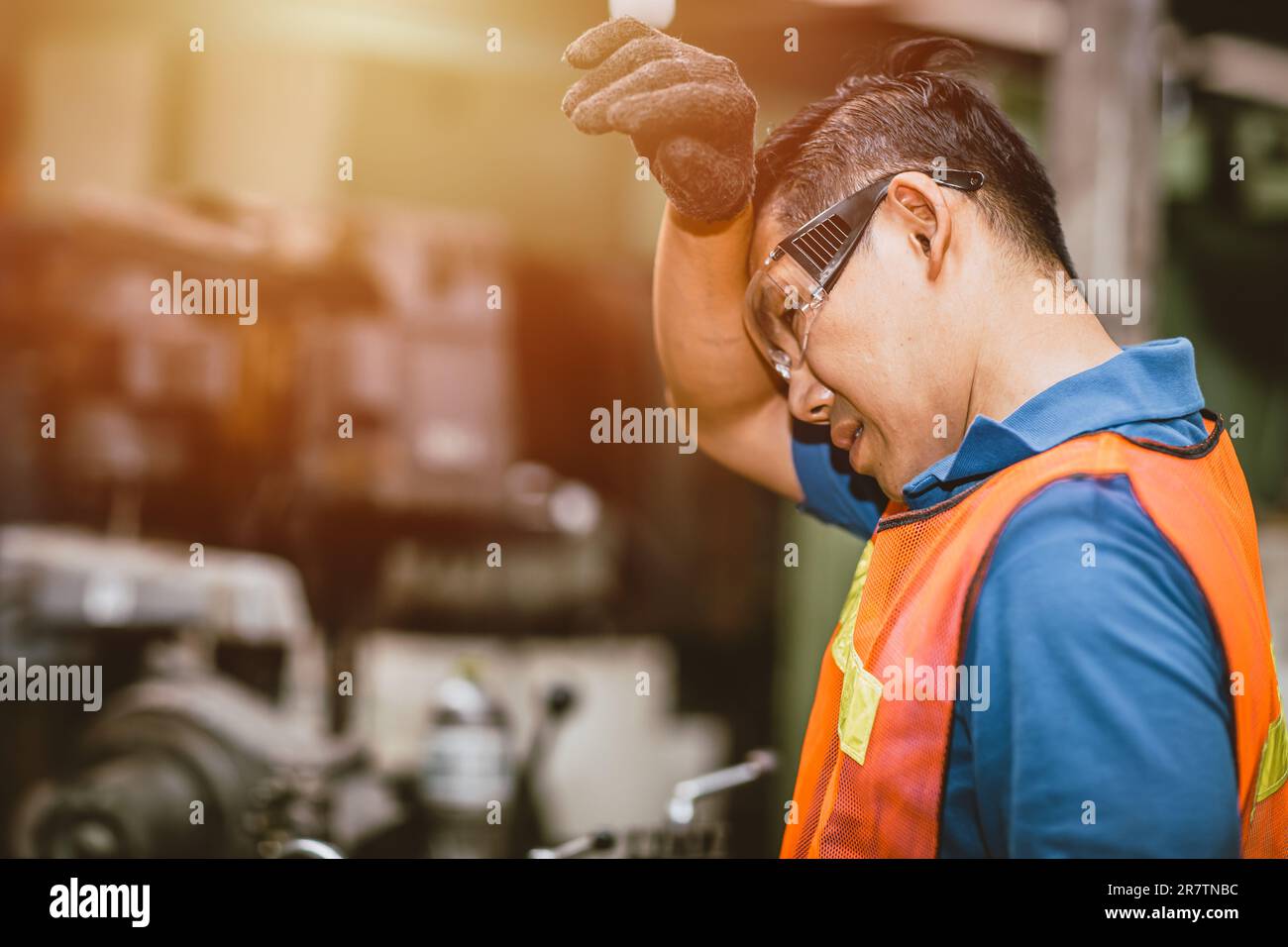 Tired fatigue exhausted engineer feel sick worker from hard working in factory sweat hot bad airflow workplace. Stock Photo