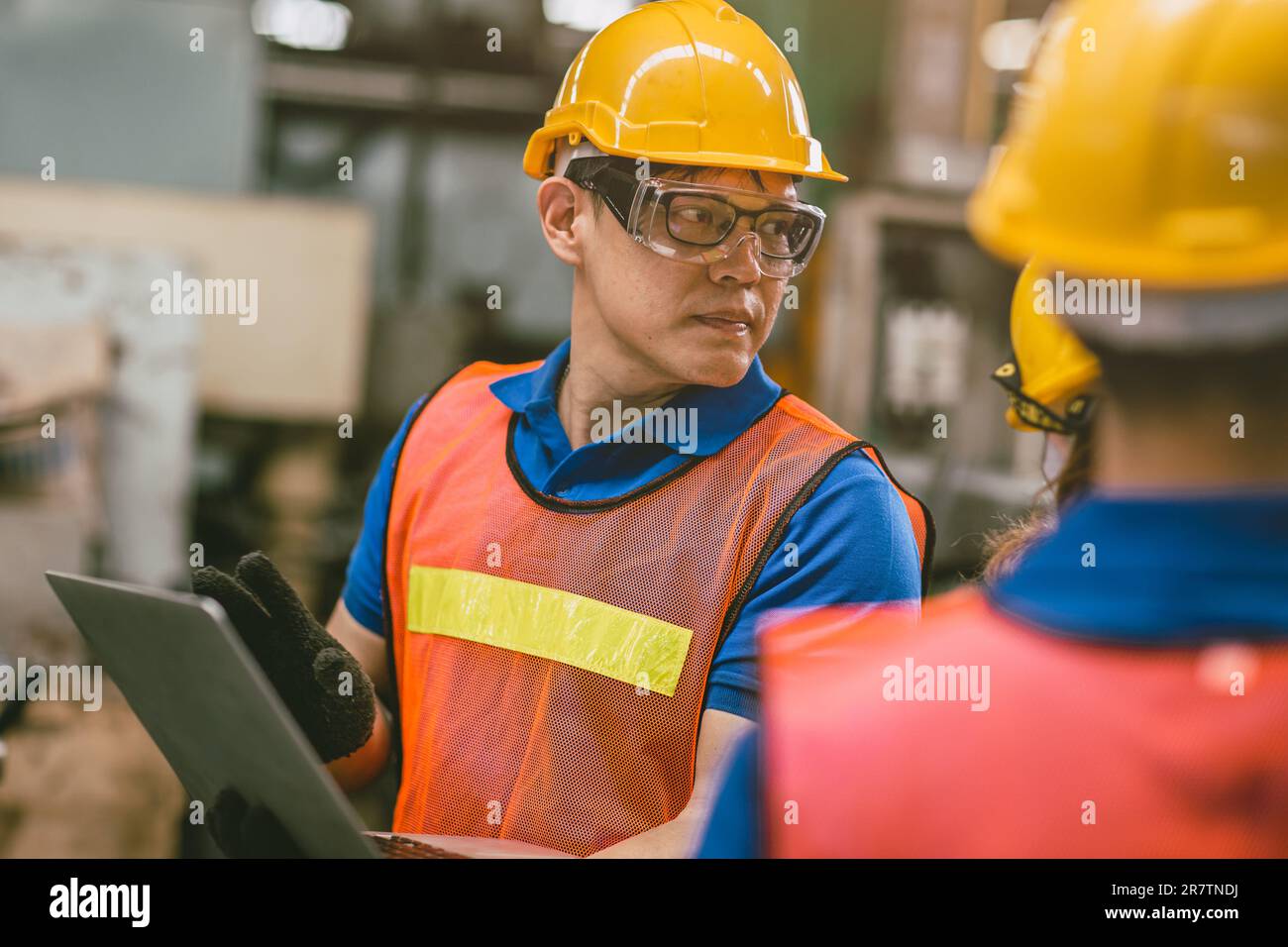 Professional Engineer Worker Male Asian working with teammate as Machine Programmer in Metal Factory Candid shot. Stock Photo