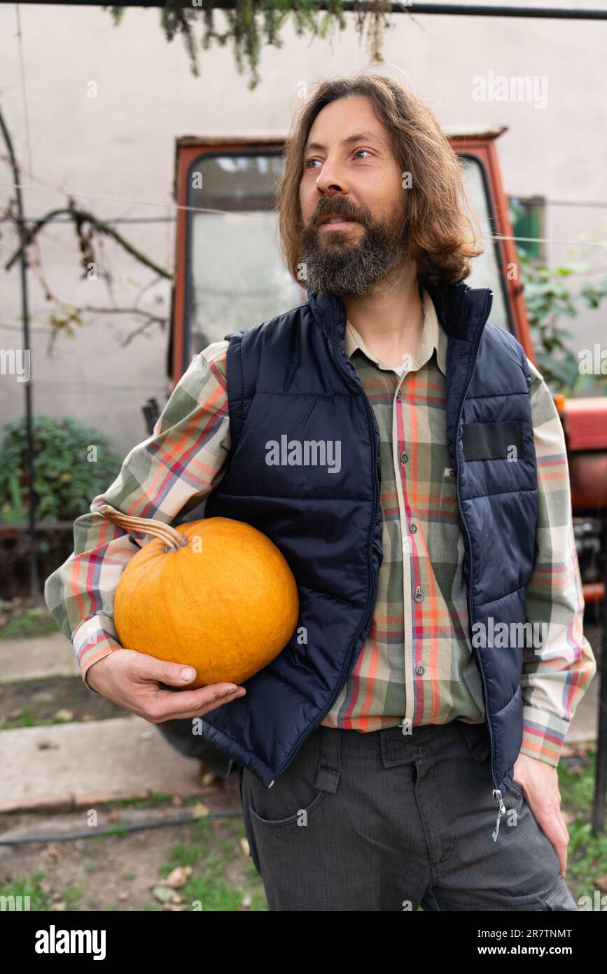 Adult bearded farmer with pumpkin Stock Photo