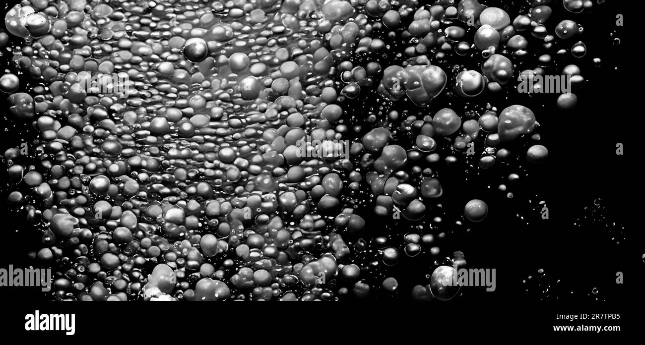 Soda water bubbles splashing underwater against black background. Cola