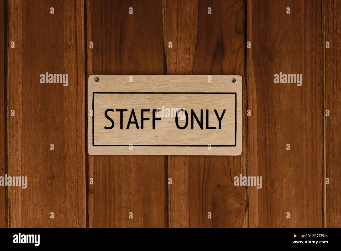 STAFF ONLY wood text badge sign banner on wooden door panel background. Stock Photo