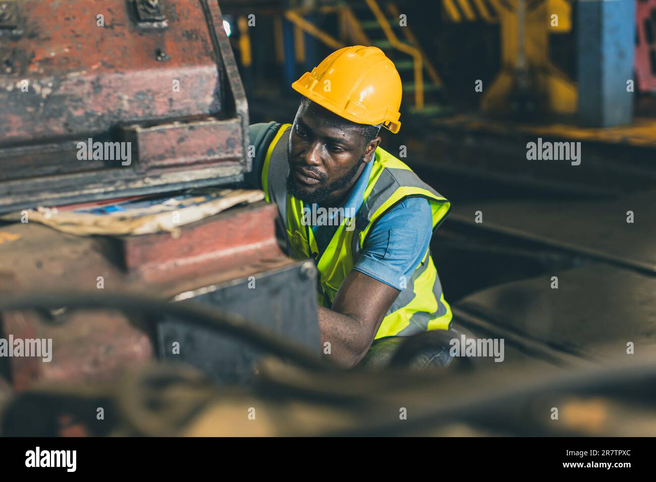 engineer male mechanic staff worker labor working in hevy industry dirty work place servicing large machine. Stock Photo