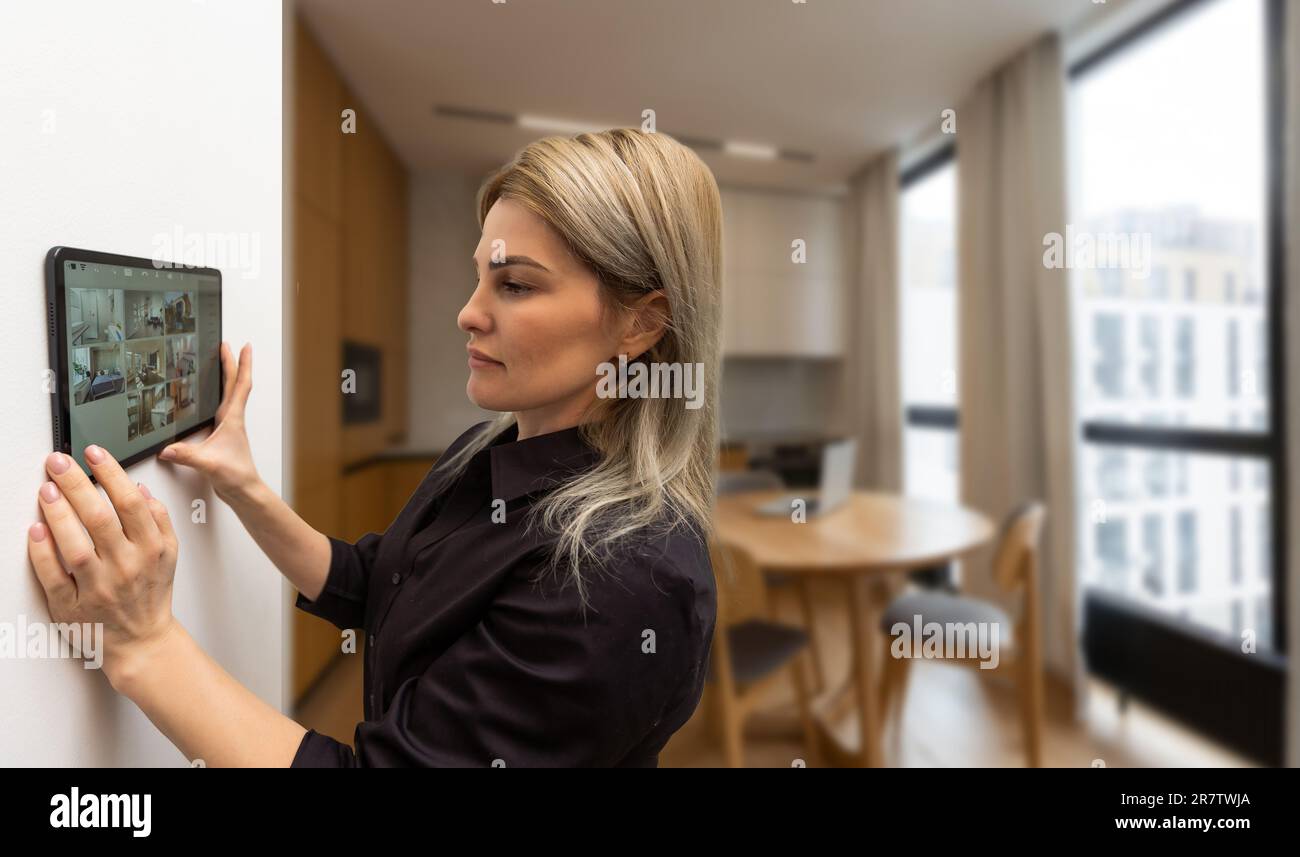 Woman using smart wall home control system Stock Photo - Alamy