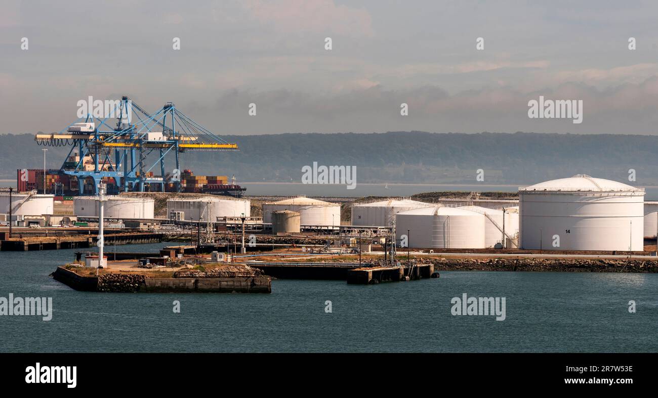 Le Havre, northern France, Europe. 2023. Cranes in the container port and storage  tanks alongside a jetty in the Port of Le Havre, France. Stock Photo