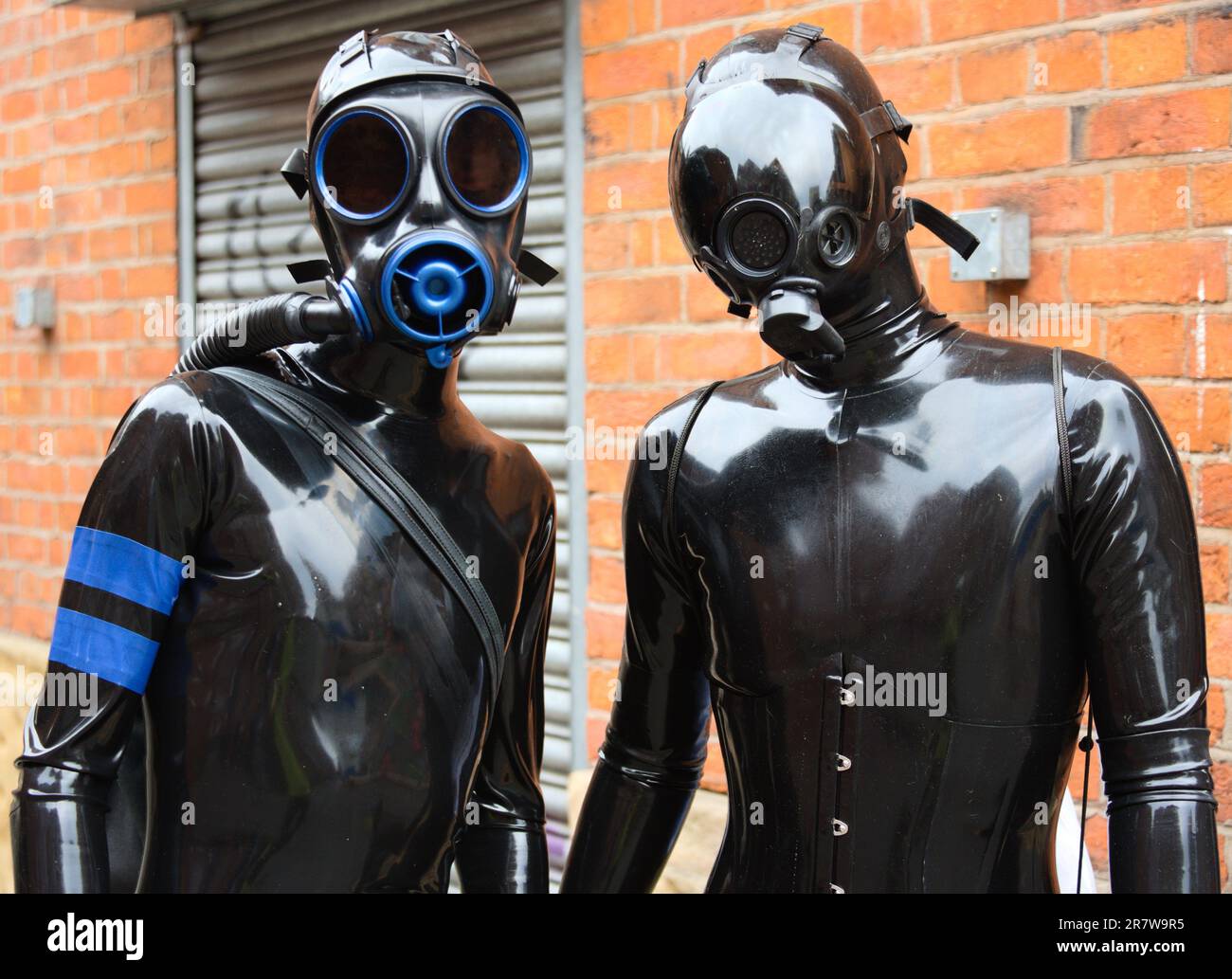 Manchester, UK, 17th June, 2023. People dressed in similar latex costumes, some wearing simulated gas masks, get ready for a walk in central Manchester as latex doppelgangers or clones. From 15th to 19th June, 2023, the 11th annual Manchester Rubber Weekend takes place in Manchester.  Credit: Terry Waller/Alamy Live News Stock Photo