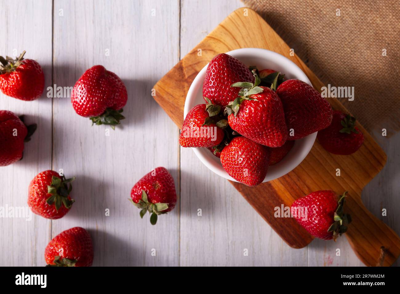 Fresh organic strawberries (fragaria) on wooden table. Also known as