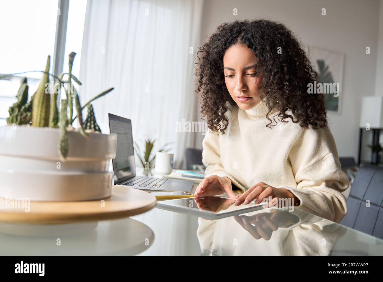Young latin girl student using digital tablet elearning or working at home. Stock Photo