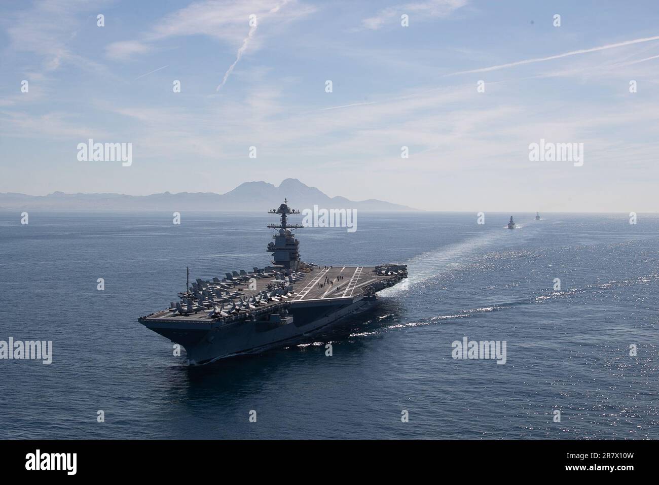 The world's largest aircraft carrier USS Gerald R. Ford (CVN 78), Italian frigate Alpino (F 594), and the Arleigh Burke-class guided-missile destroyer USS Roosevelt (DDG 80) transit the Strait of Gibraltar, June 15, 2023. Gerald R. Ford is the U.S. Navy's newest and most advanced aircraft carrier, representing a generational leap in the U.S. Navy's capacity to project power on a global scale. The Gerald R. Ford Carrier Strike Group is on a scheduled deployment in the U.S. Naval Forces Europe area of operations, employed by U.S. Sixth Fleet to defend U.S., allied, and partner interests. (U.S. N Stock Photo