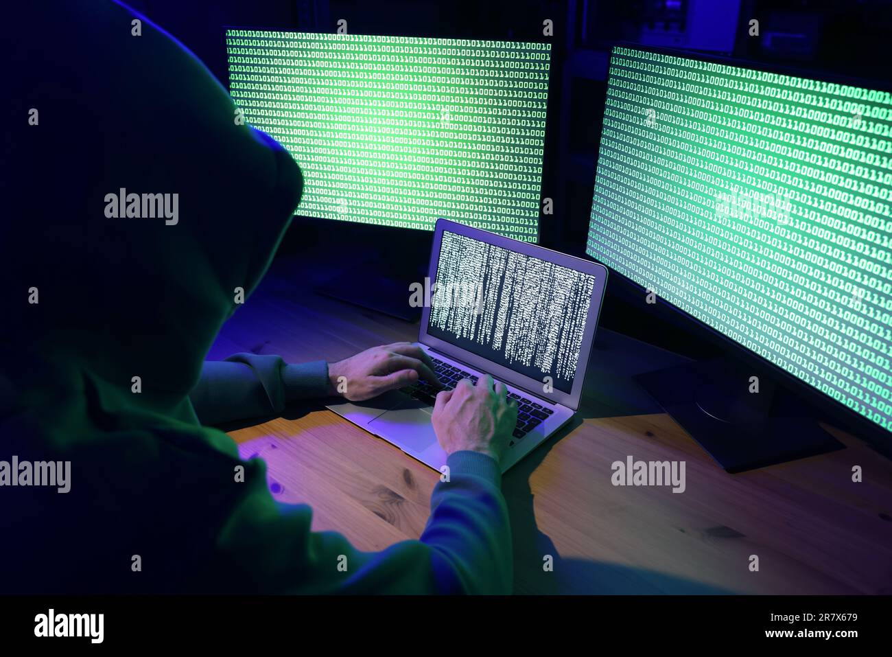 Hacker working with computers at wooden table indoors. Cyber attack Stock Photo