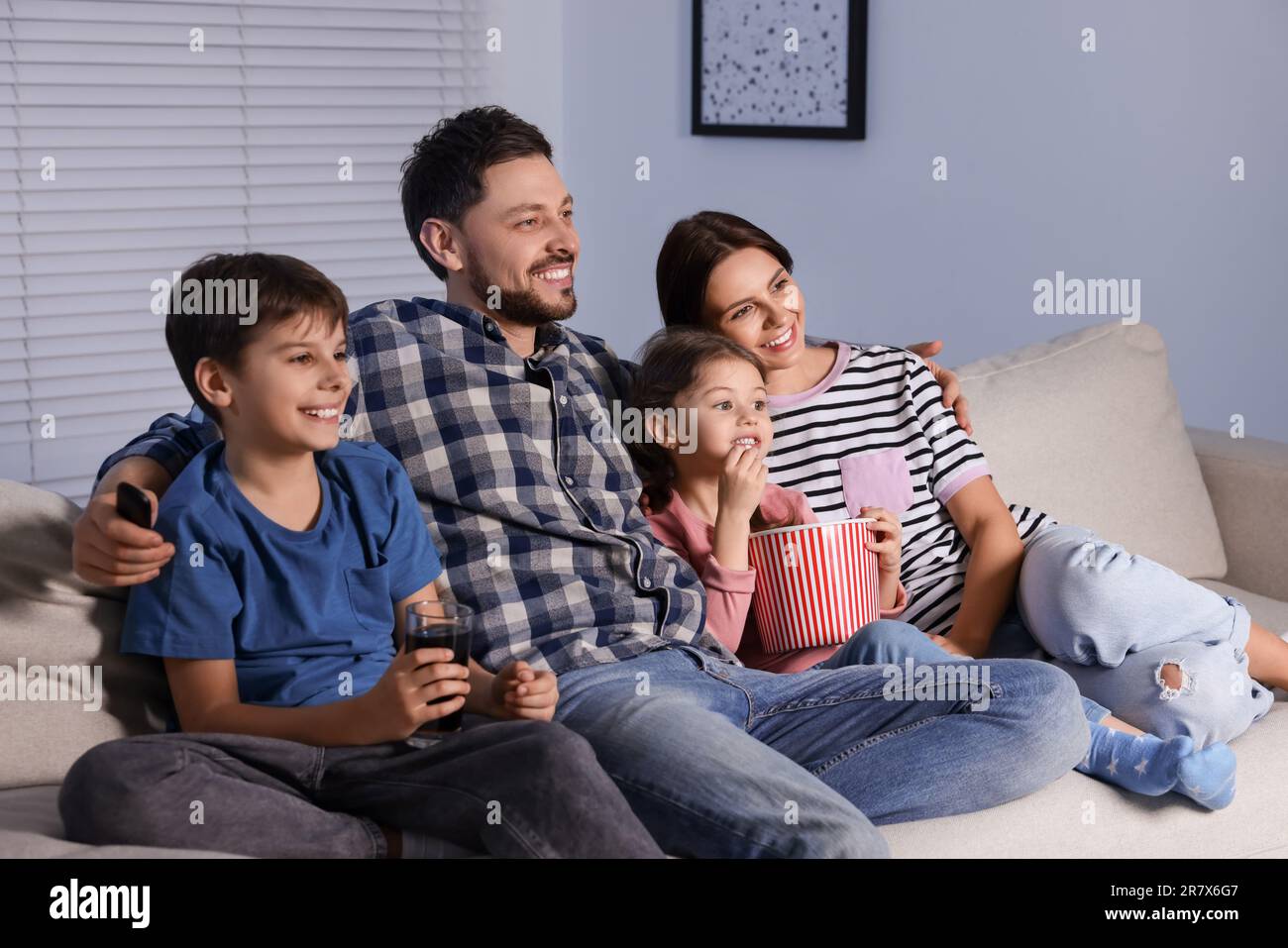 Happy family watching TV at home in evening Stock Photo - Alamy