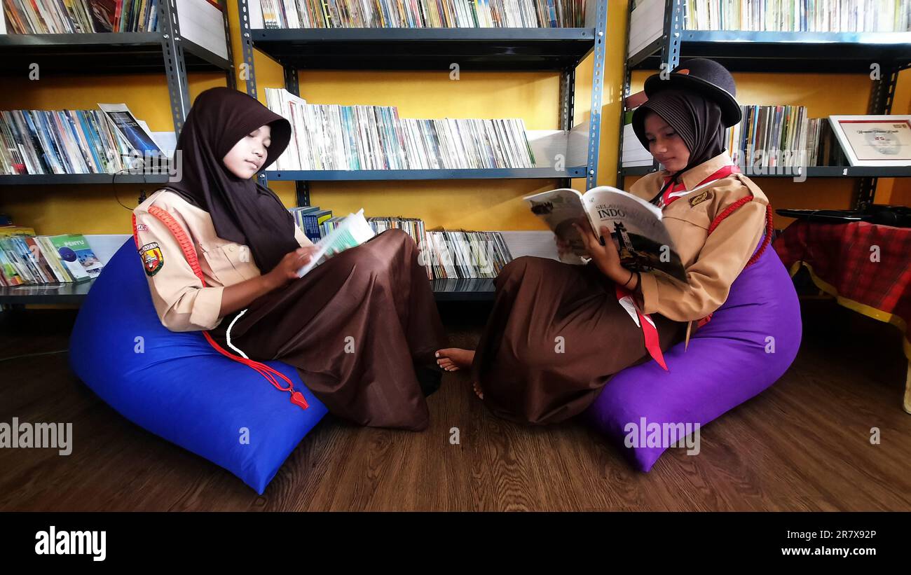 June 17, 2023, Bogor, West Java, INDONESIA: Students and teachers read in a library with a more relaxed design and form at Singajaya 06 state elementary school, Bogor, West Java, on June 17, 2023. Revitalization, the library provides a solution to increase students' interest in reading through the application of color and shape psychology to the interior design of the library with a more relaxed and attractive concept in improving the quality of education for students to visit the library which is comfortable and fun in new innovations. (Credit Image: © Dasril Roszandi/ZUMA Press Wire) EDITORI Stock Photo
