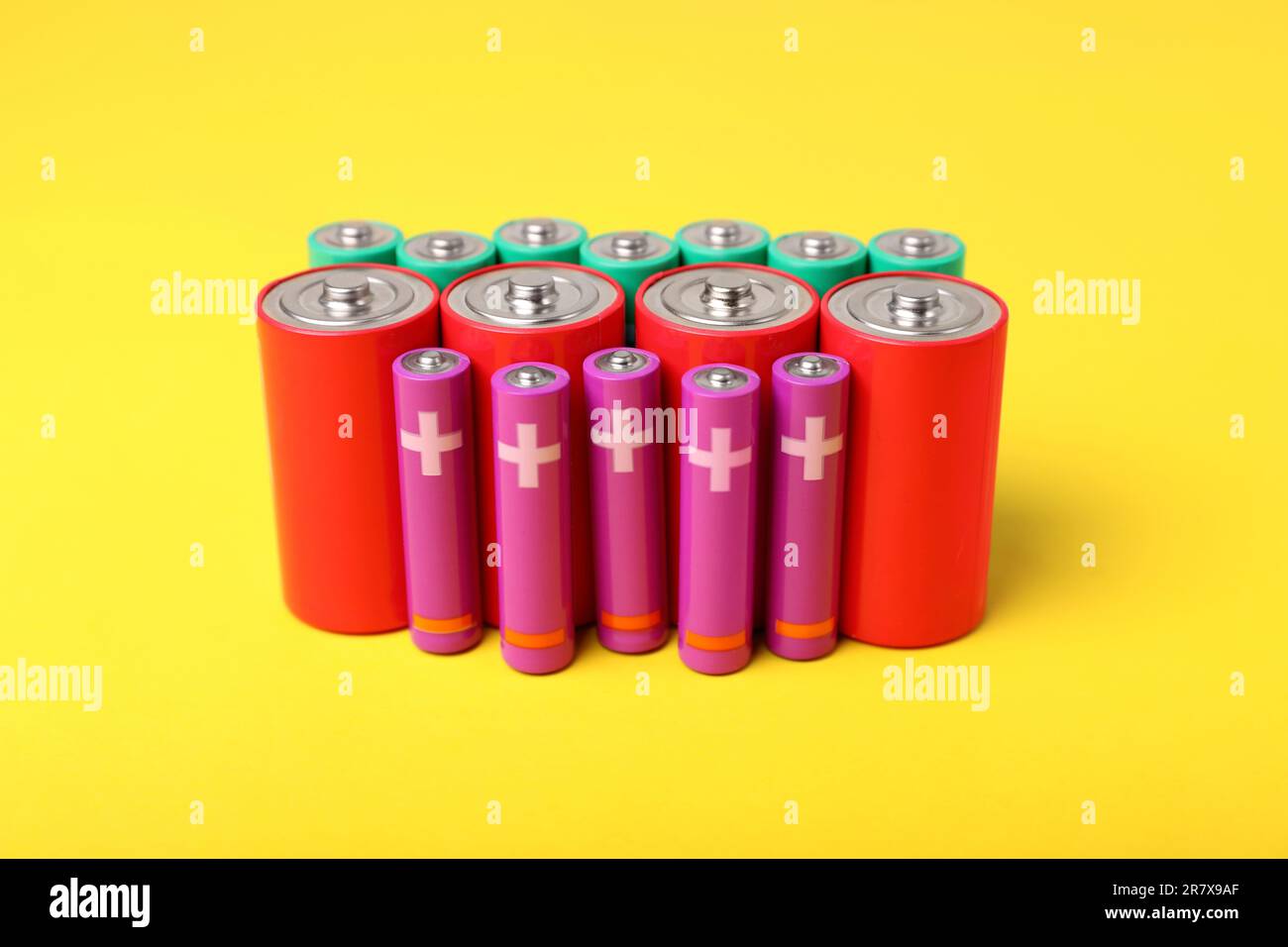 Batteries of different sizes on yellow background Stock Photo