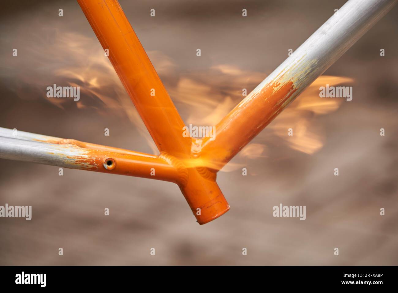 Manual bicycle renovation work, paint removal process using a torch