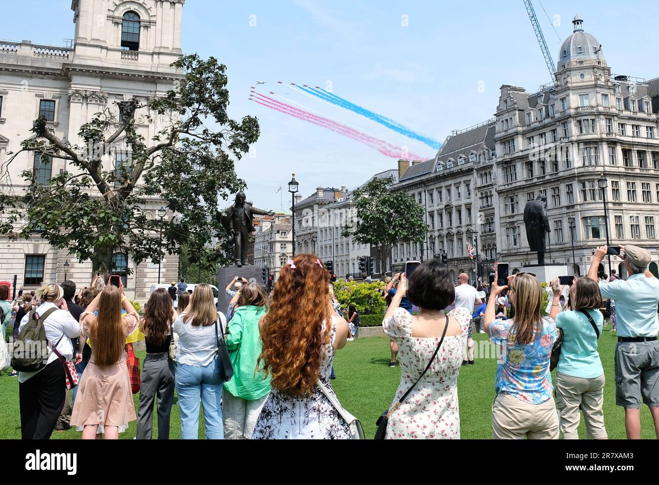 London, UK. 17th June, 2023. Members of the public on parliament Square enjoy the spectacle of the Red Arrows flying over Whitehall. The Trooping the Colour celebrations marking the King's birthday concluded with a flypast, consisting of around 70 aircraft from the Royal Navy, British Army and the Royal Airforce taking part in the extended display, rearranged after May's Coronation flypast was scaled down due to poor weather condtions. Credit: Eleventh Hour Photography/Alamy Live News Stock Photo