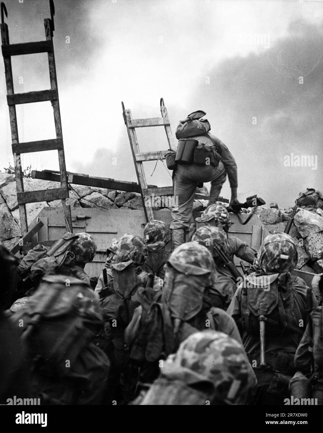 First Lieutenant Baldomero Lopez, USMC, leads the 3rd Platoon, Company A, 1st Battalion, 5th Marines over the seawall on the northern side of Red Beach, as the second assault wave lands, 15 September 1950, during the Inchon invasion. Wooden scaling ladders are in use to facilitate disembarkation from the LCVP that brought these men to the shore. Lt. Lopez was killed in action within a few minutes Stock Photo