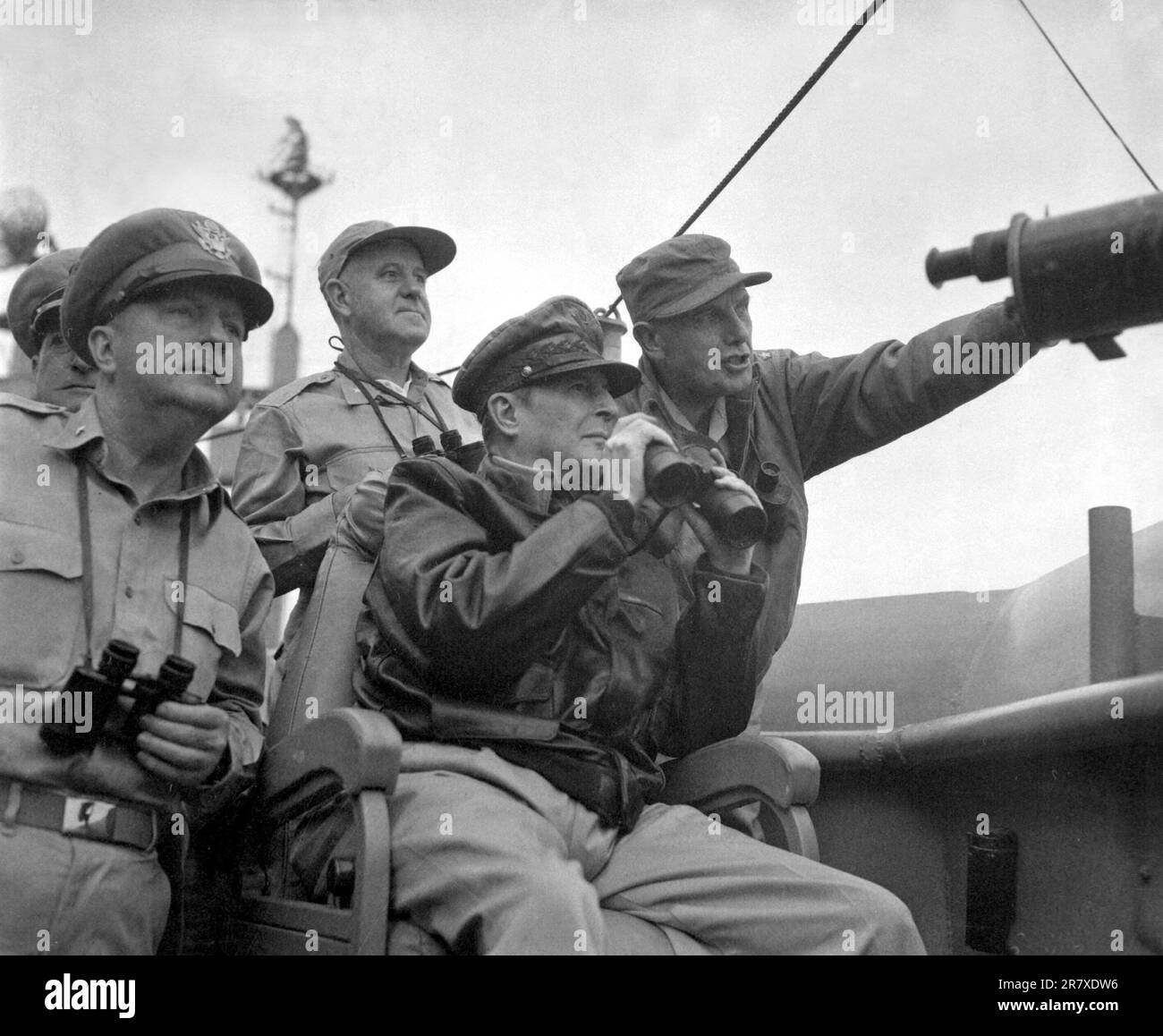 Brig. Gen. Courtney Whitney; Gen. Douglas MacArthur, Commander in Chief of U.N. Forces; and Maj. Gen. Edward M. Almond observe the shelling of Inchon from the U.S.S. Mt. McKinley, September 15, 1950. Stock Photo