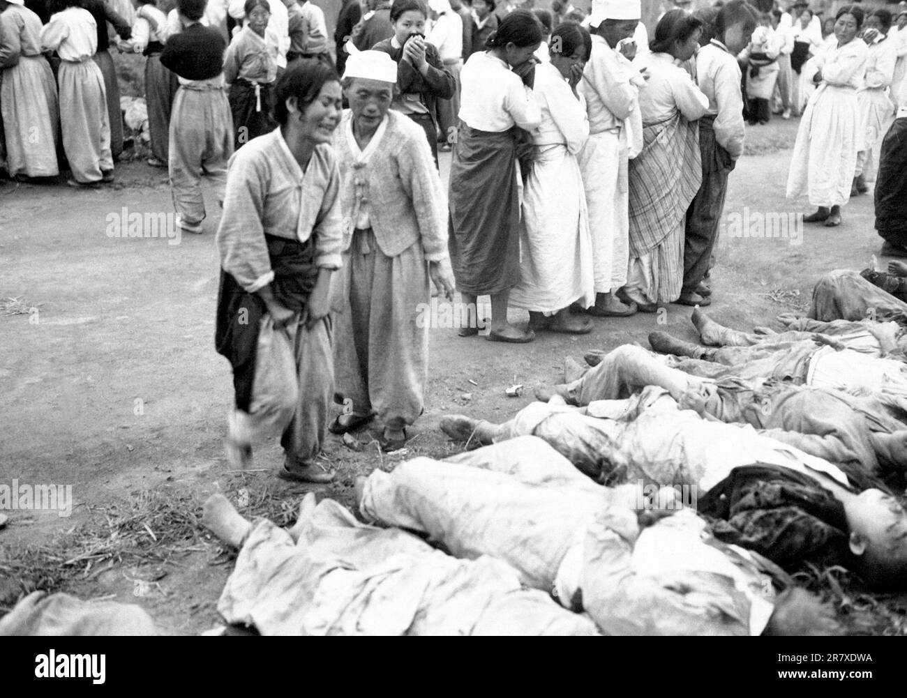 Koreans from Hamhung identify the bodies of some 300 political prisoners who were killed by the North Korean Army by being forced into caves which were subsequently sealed off so that they died of suffocation.  October 19, 1950. Stock Photo