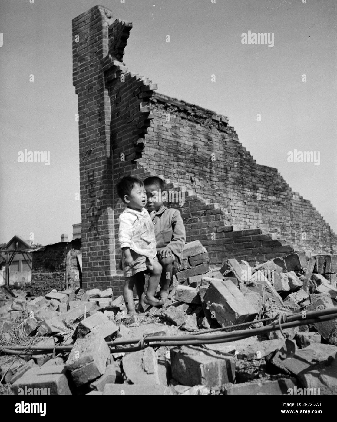 Two orphans lost in the ruins of Incheon during teh Korean War Stock Photo