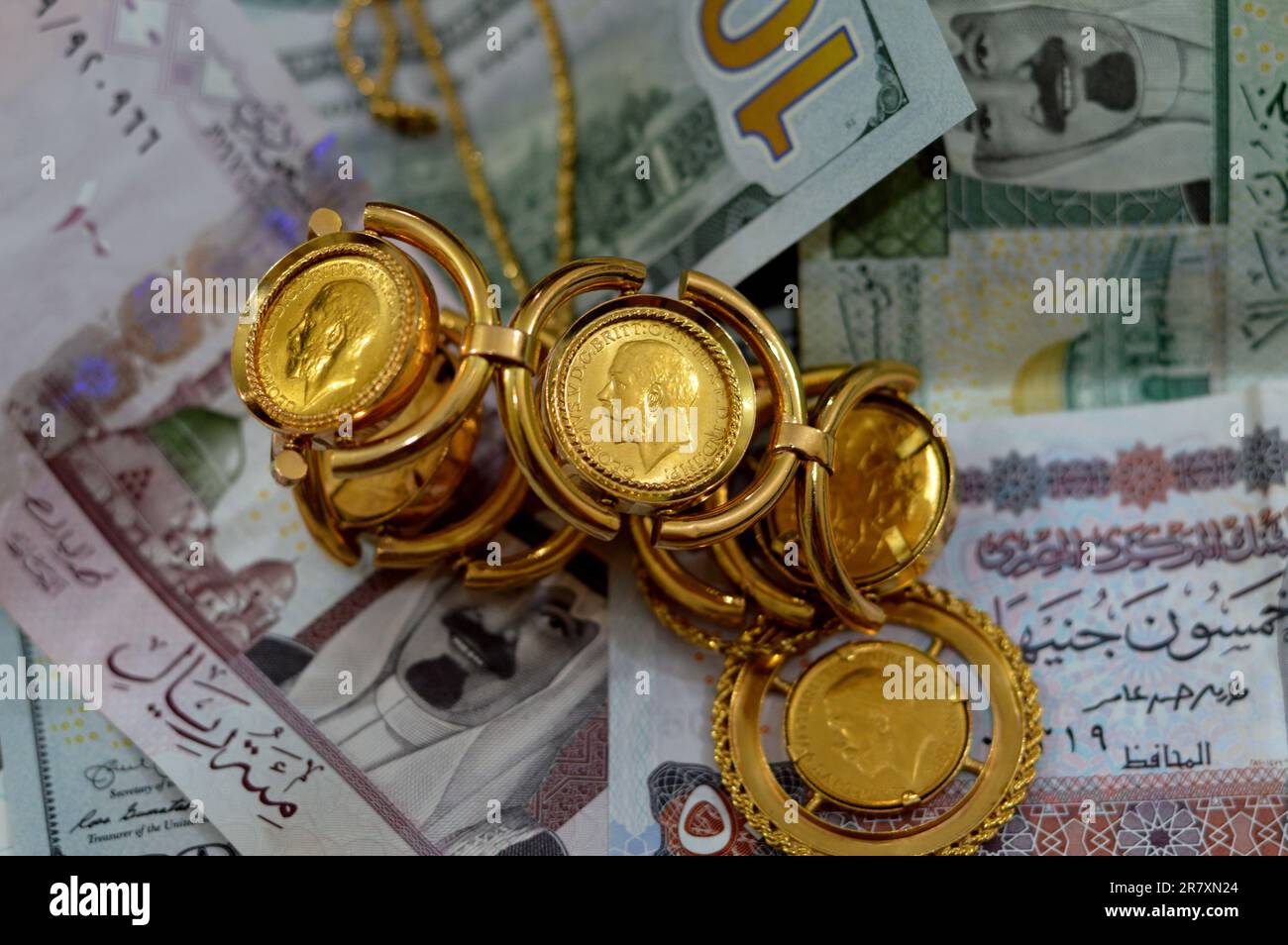 American dollars, Egyptian pounds and Saudi Arabia Riyals banknotes currency bills money with sovereign British gold coins shapes bullion coin feature Stock Photo