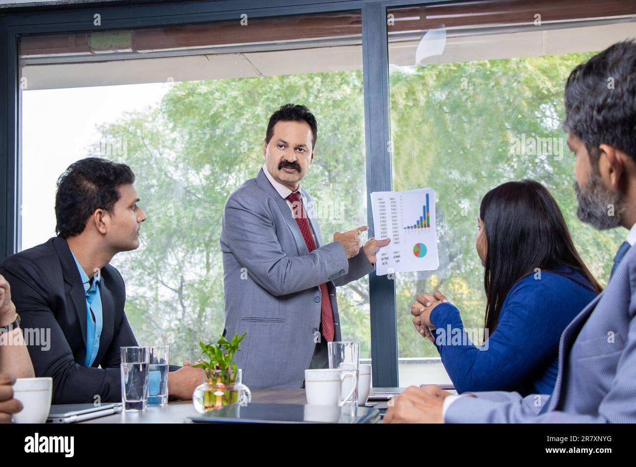 Indian businessman discussing with employees about finance and success