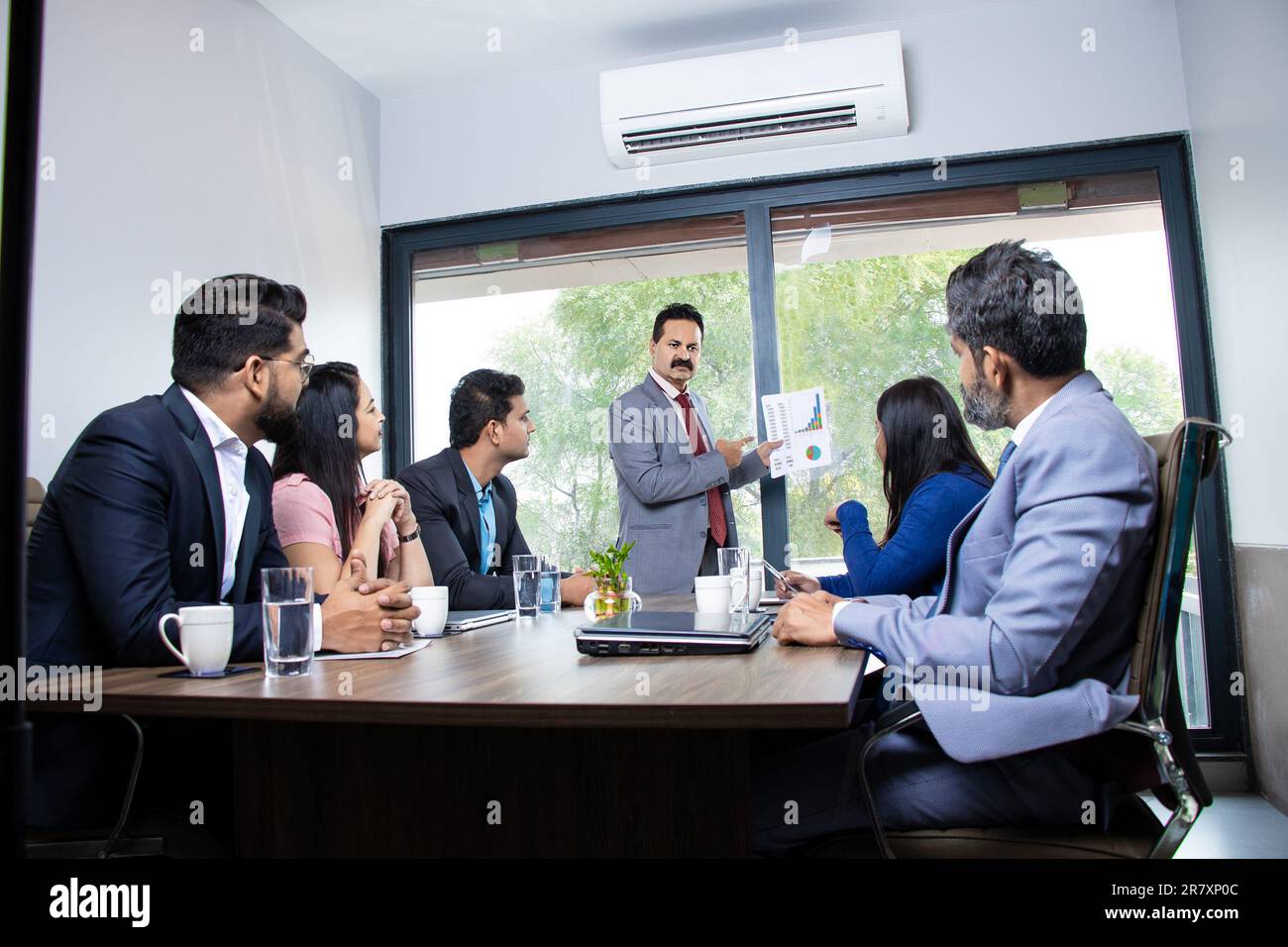 Indian businessman discussing with employees about finance and success