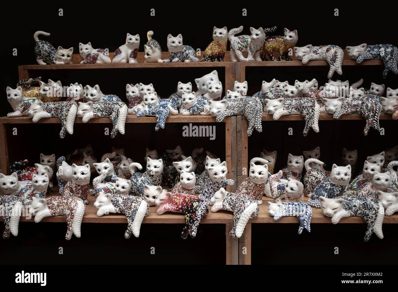 Plenty of porcelain cat figurines lined up on shelves in a gift shop Stock Photo