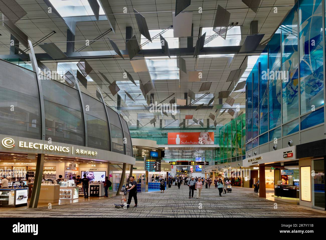 Inside Terminal 2 of award-winning Changi International Airport, Singapore, with duty-free shops and passengers Stock Photo
