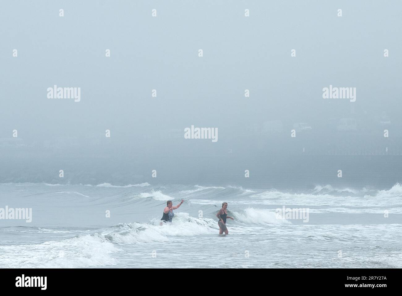 Scarborough, North Yorkshire, UK. 18th June 2023. Early morning swimmers exit the sea on as the mist rolls in at North Bay, Scarborough, North Yorkshire. Neil Squires/Alamy Live News Stock Photo