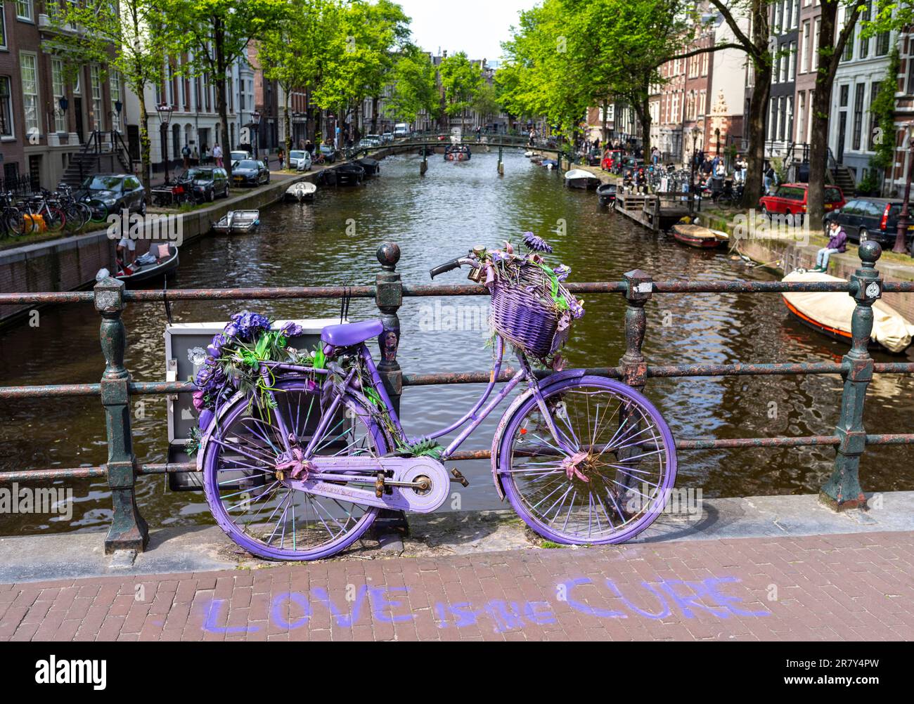 A purple bicycle on a canal bridge at Lijnbaansgracht Amsterdam, Netherlands. Stock Photo