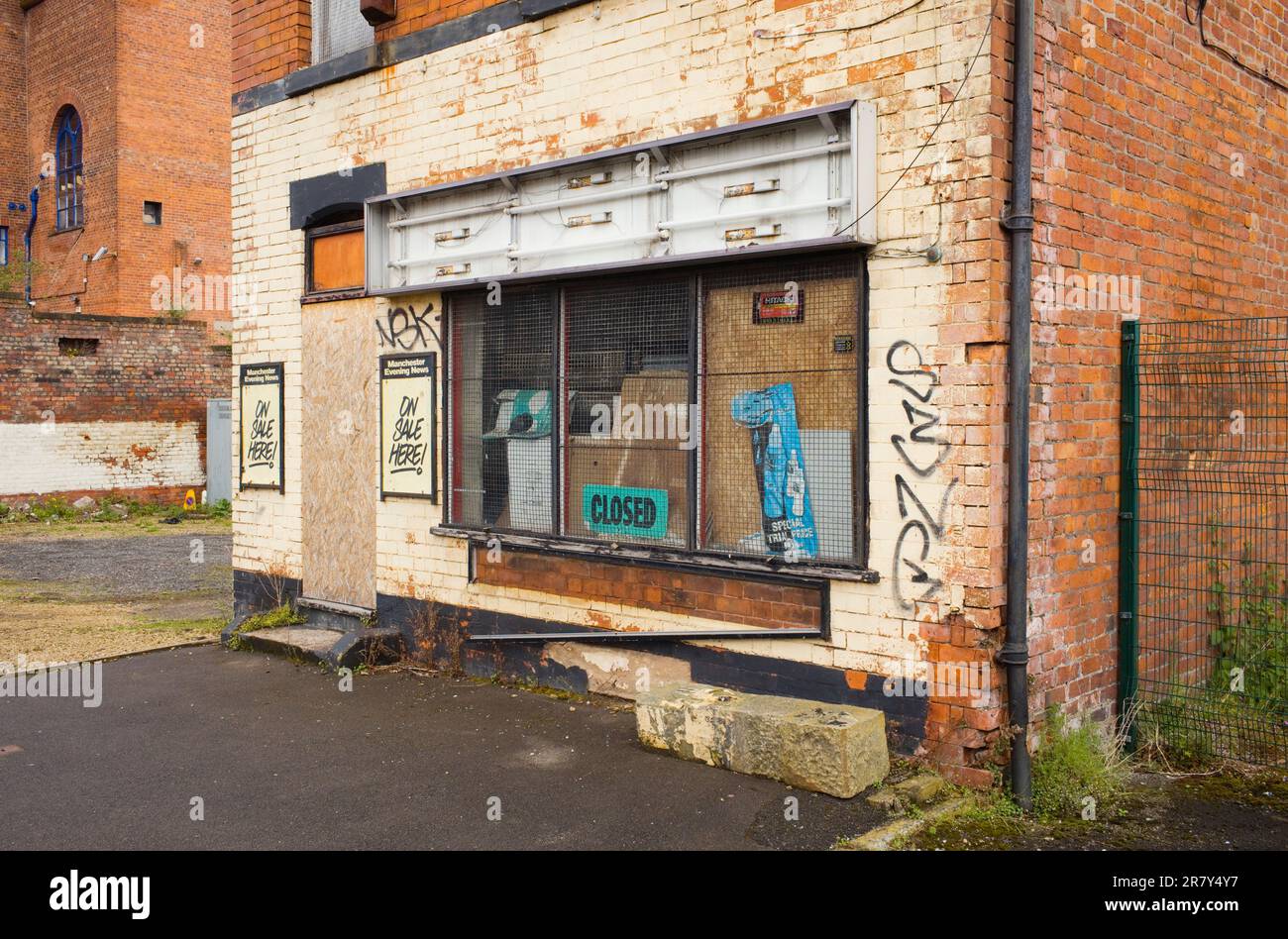A closed and boarded up newsagents shop near the river Mersey in Stockport Stock Photo