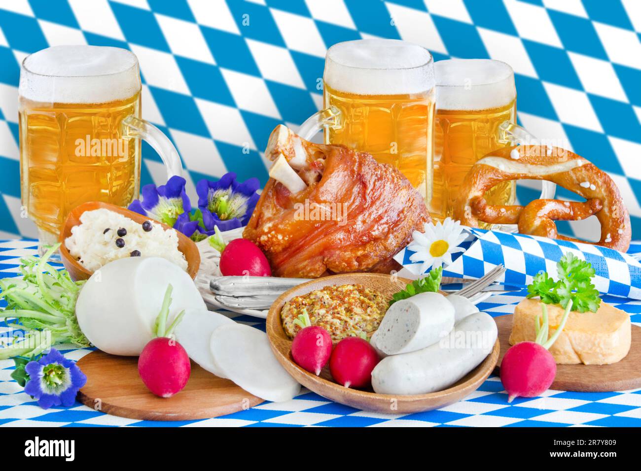 Oktoberfest mit Bier, Haxe, Weisswurst, Radi und Bayerische Flagge blau weiß im Hintergrund Stock Photo