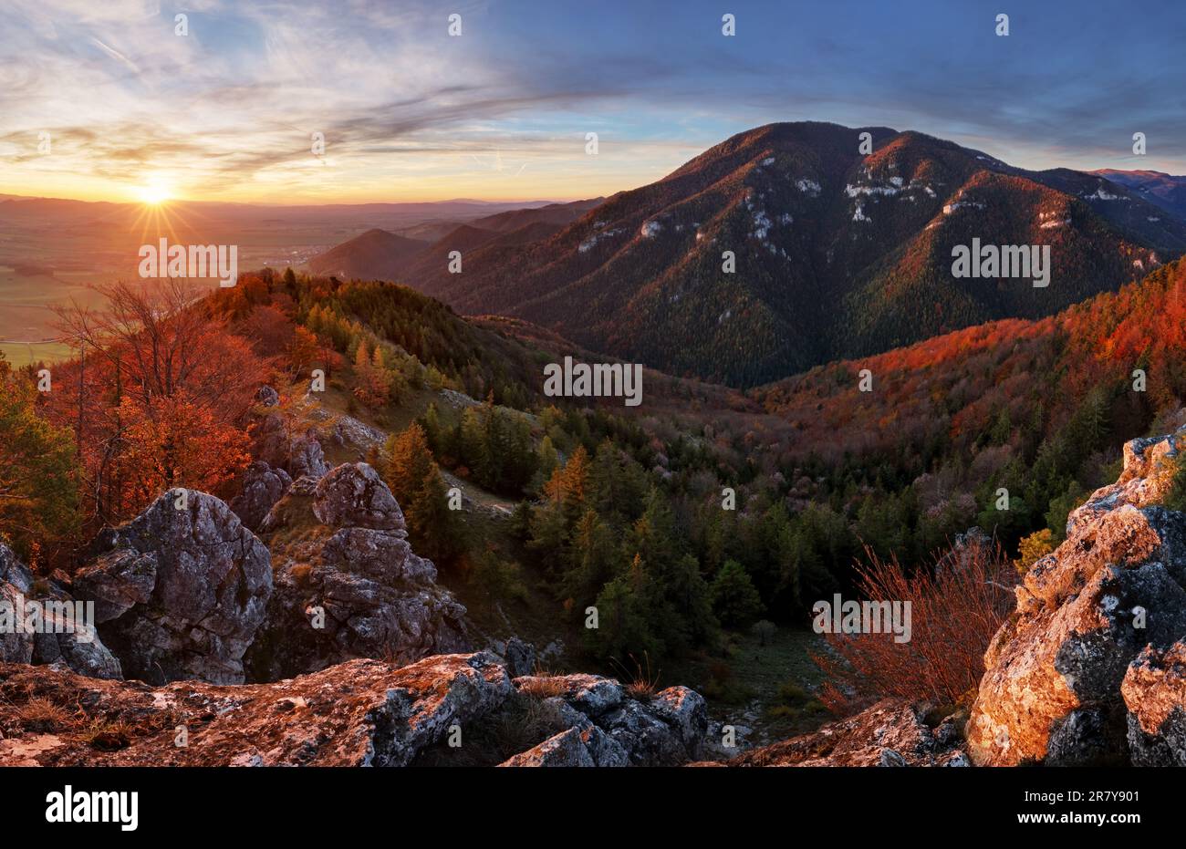 Mountain at sunset with sun and forest Stock Photo